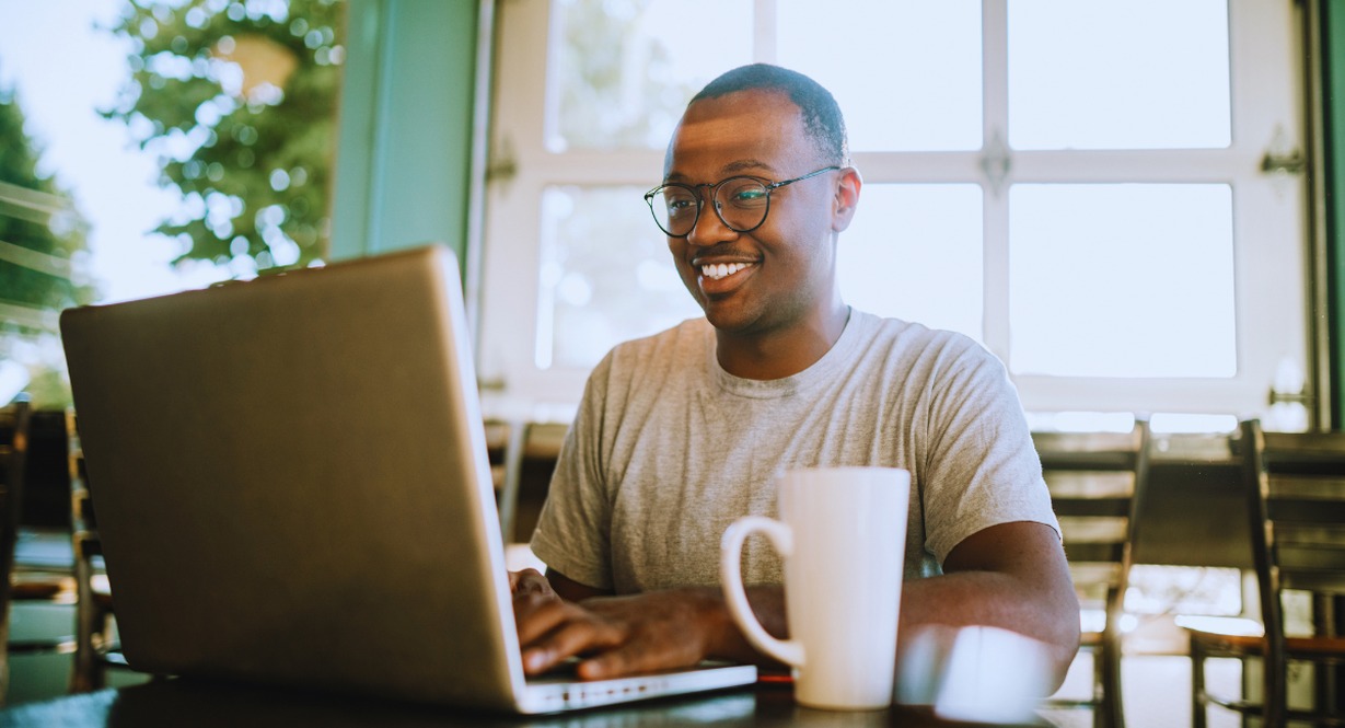 Travailleur indépendant souriant utilisant un ordinateur portable
