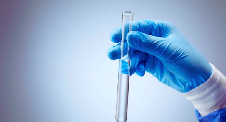 Main gantée tenant un tube à essai en laboratoire médical