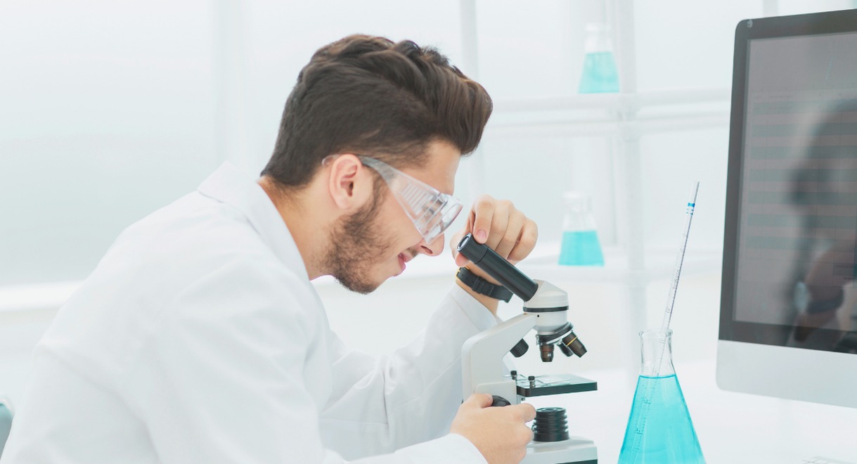 Scientifique observant un echantillon au microscope dans un laboratoire de recherche