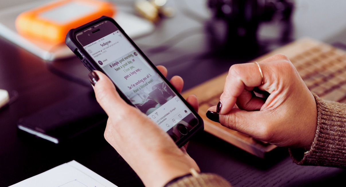 Mains tenant un smartphone affichant une application de messagerie