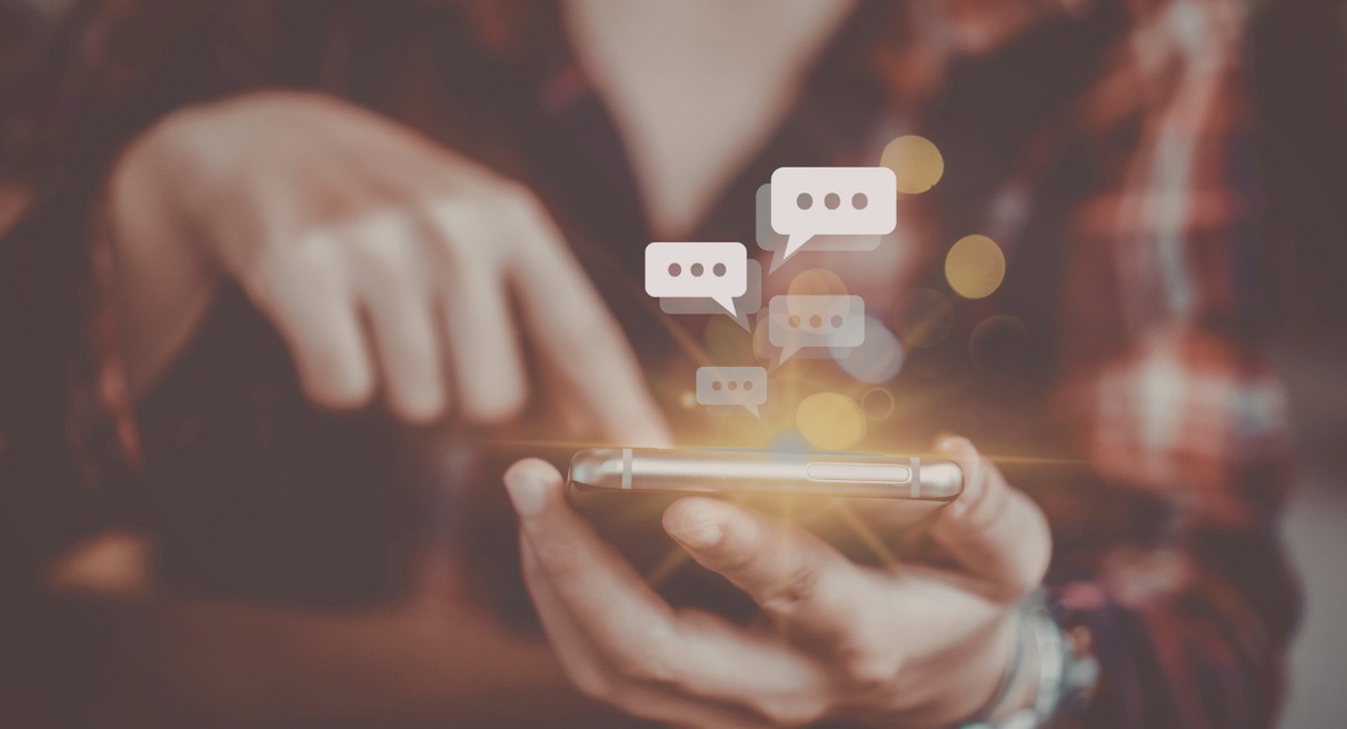 Personne échangeant des messages avec des bulles de chat sur smartphone