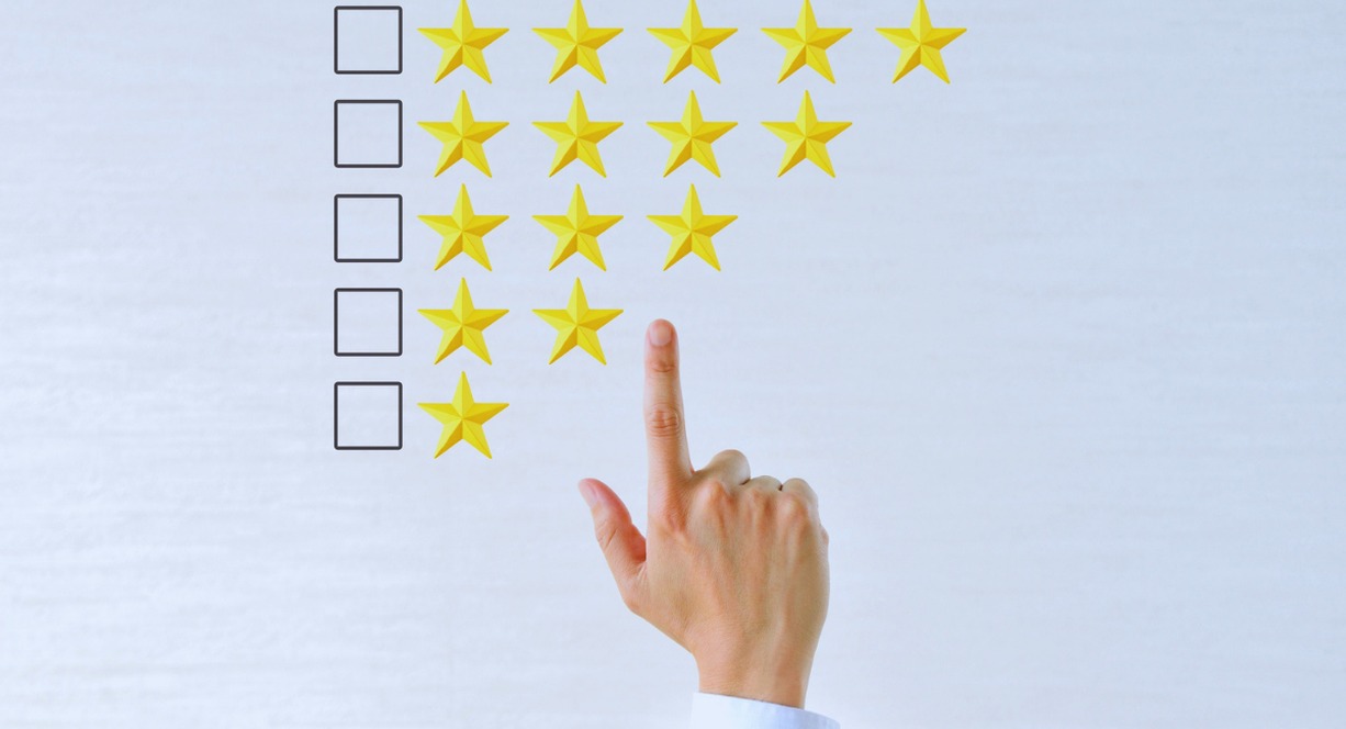 Main selectionnant une note par etoiles sur un tableau d'evaluation